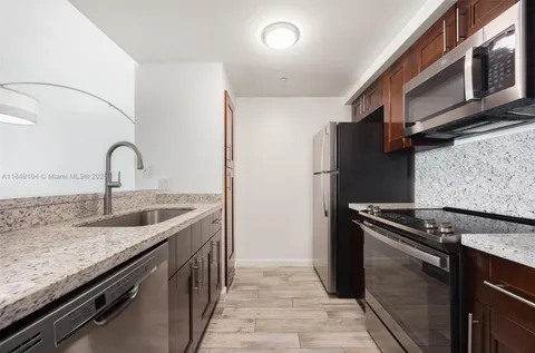 a kitchen with granite countertop a sink stove and refrigerator
