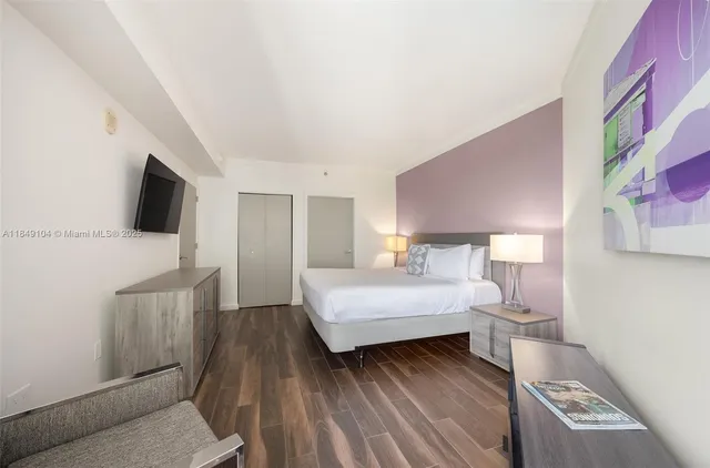 a bedroom with a bed and a flat screen tv