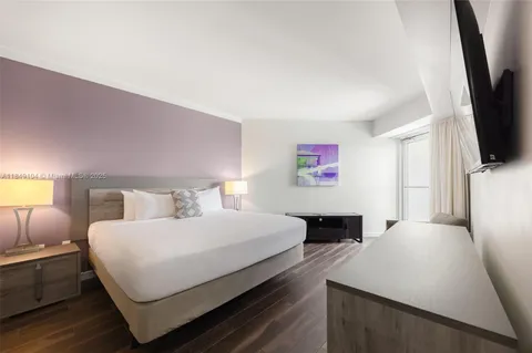 a bedroom with a bed and a flat screen tv