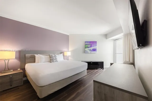 a bedroom with a bed and a flat screen tv