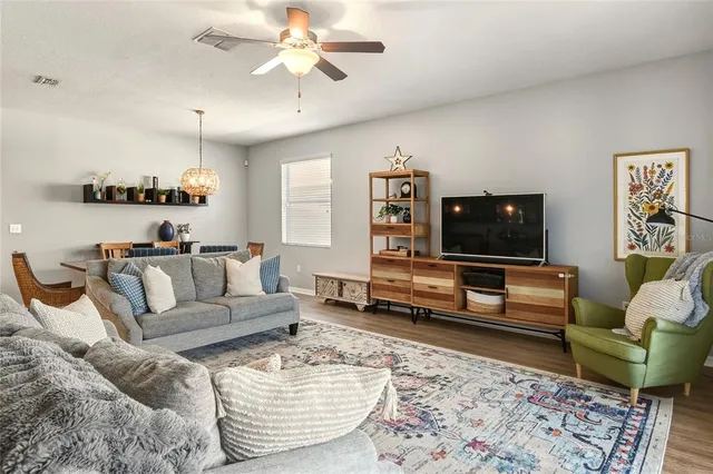 a living room with furniture ceiling fan and a window