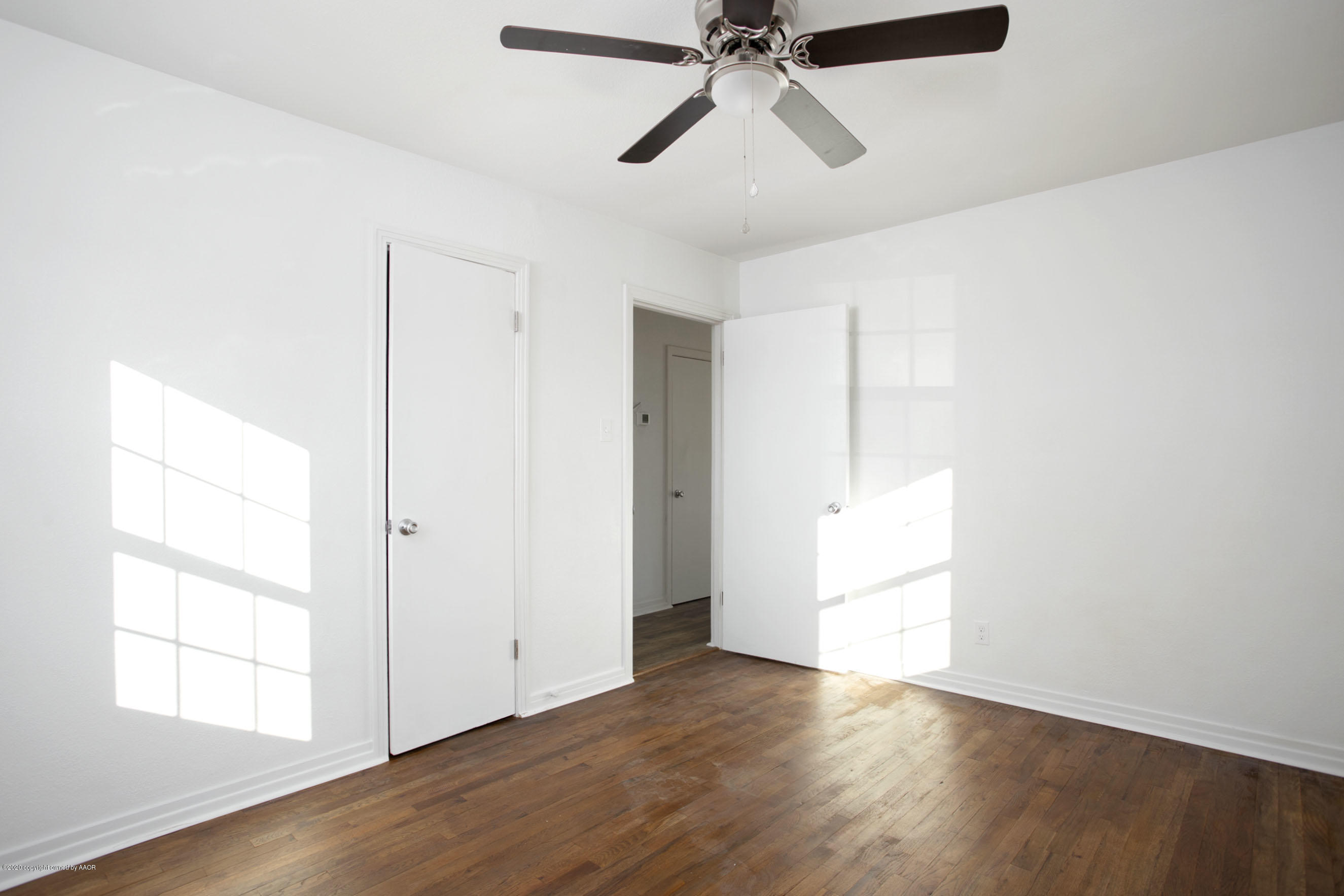 4408 South Travis Street Amarillo, TX 79110 - Photo 11 of 25 a view of empty room with wooden floor and fan