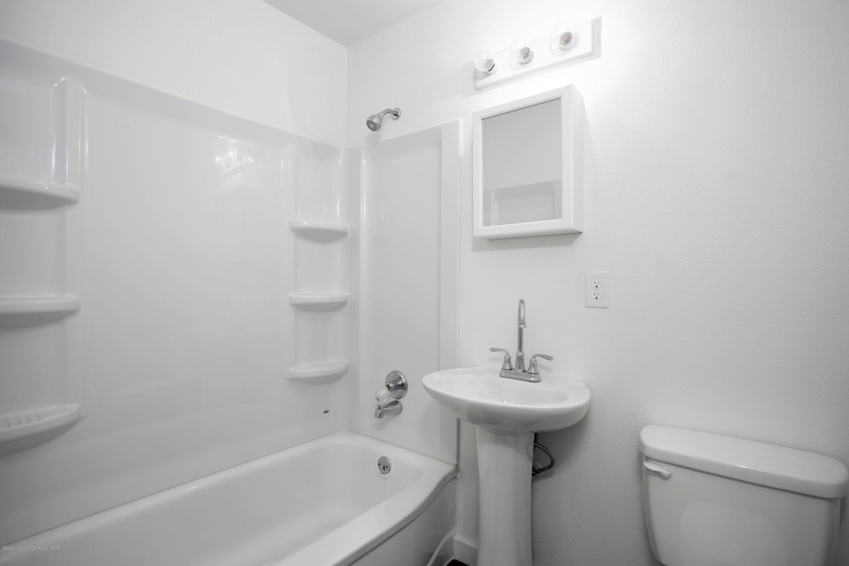 4408 South Travis Street Amarillo, TX 79110 - Photo 13 of 25 a bathroom with a sink a toilet and shower