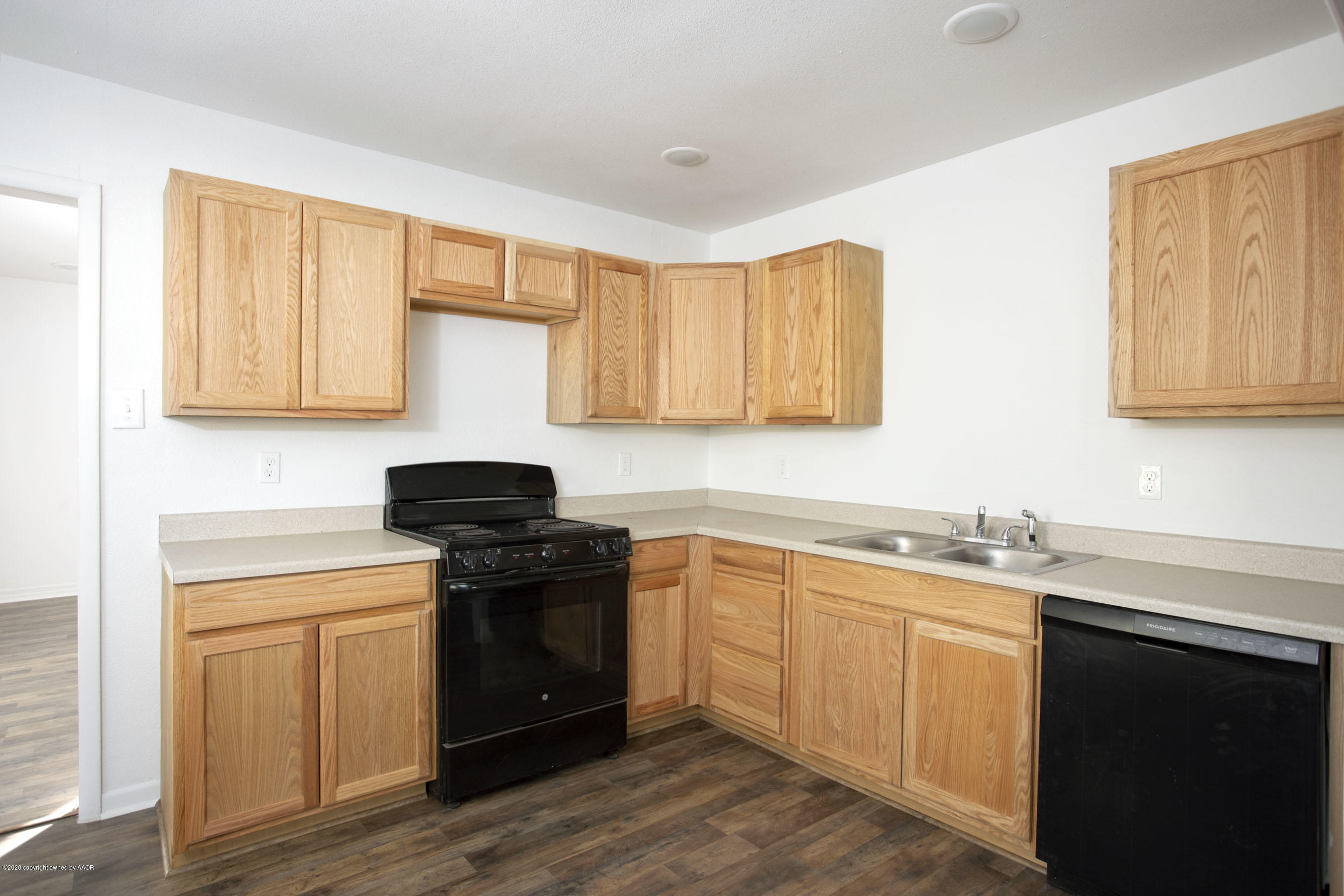 4408 South Travis Street Amarillo, TX 79110 - Photo 5 of 25 a kitchen with stainless steel appliances granite countertop a sink stove and wooden cabinets