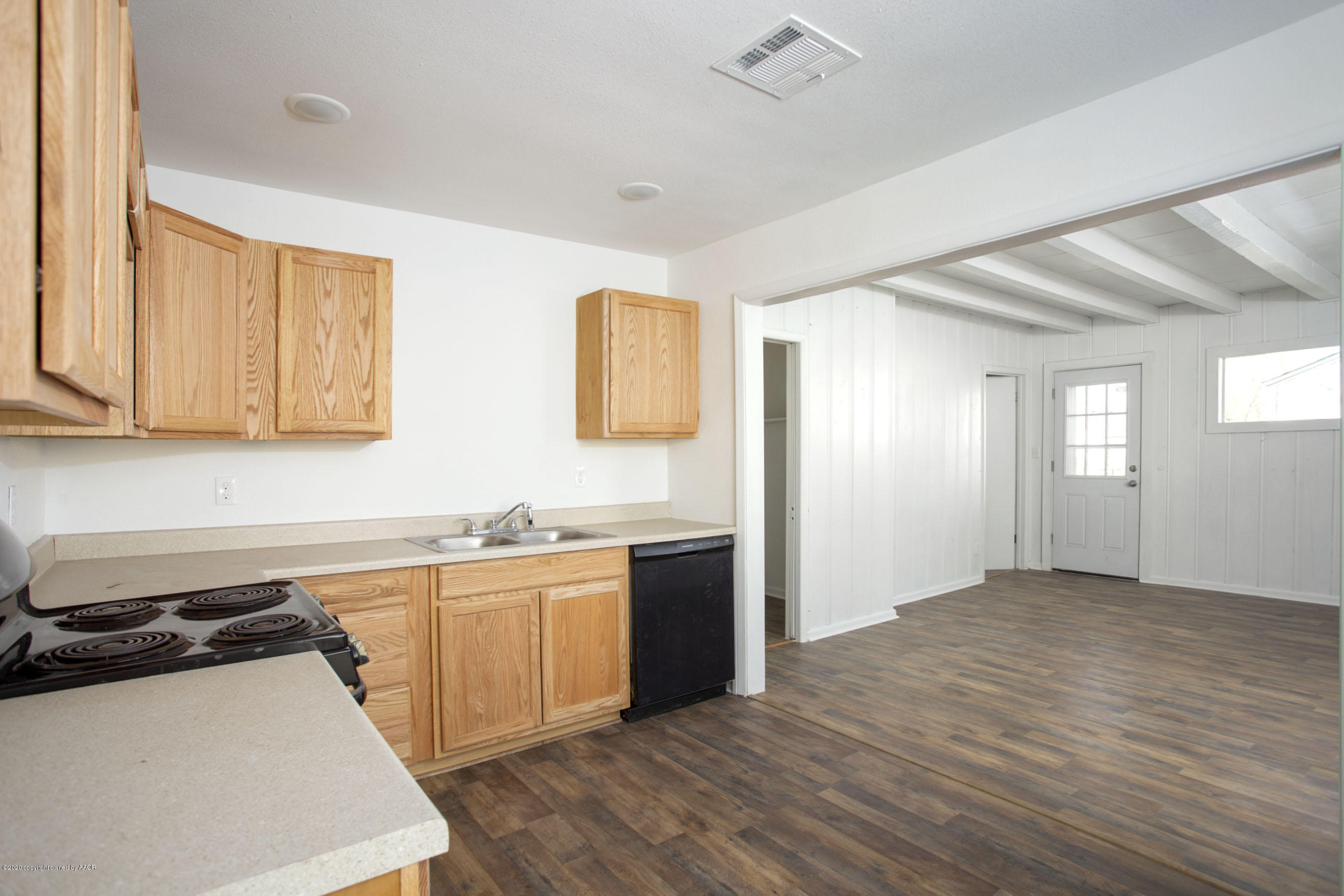 4408 South Travis Street Amarillo, TX 79110 - Photo 7 of 25 a kitchen with stainless steel appliances granite countertop a sink and cabinets with wooden floor
