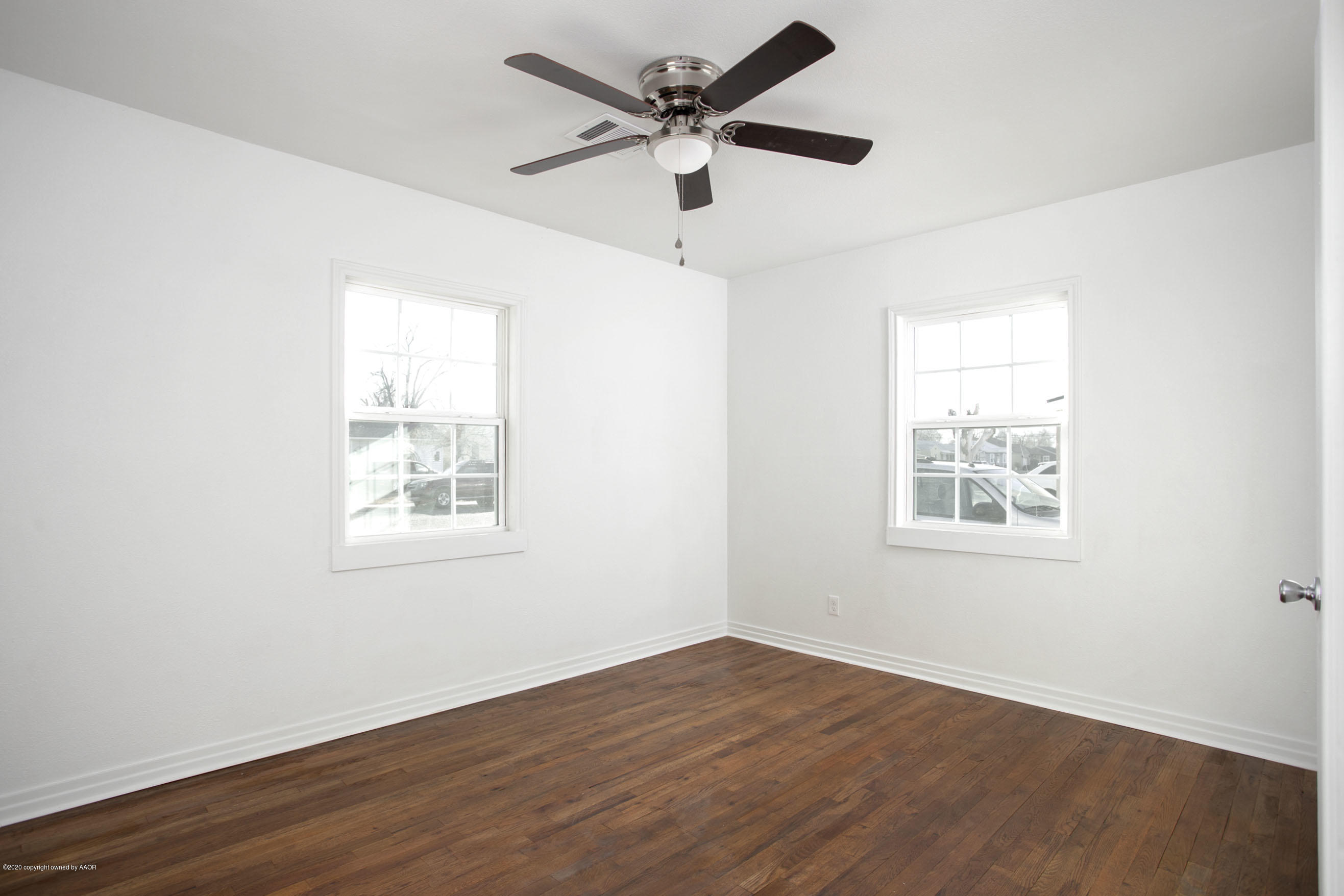 4408 South Travis Street Amarillo, TX 79110 - Photo 10 of 25 a view of an empty room with wooden floor and a window