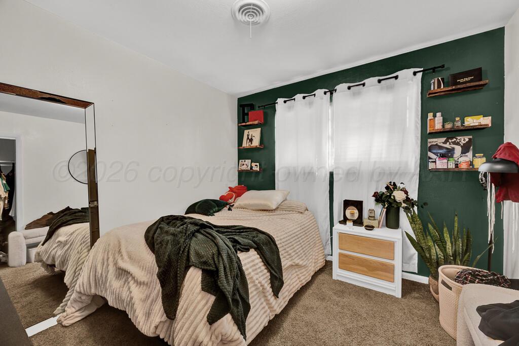 4613 South Bryan Street Amarillo, TX 79110 - Photo 11 of 16 a bedroom with a bed and a mirror