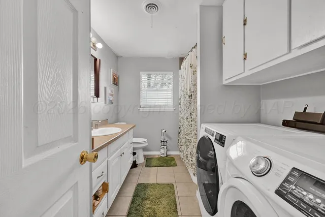 a utility room with sink dryer and washer