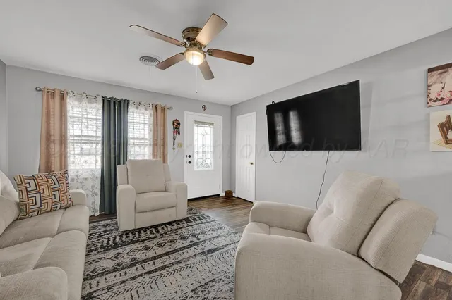 a living room with furniture a flat screen tv and a window