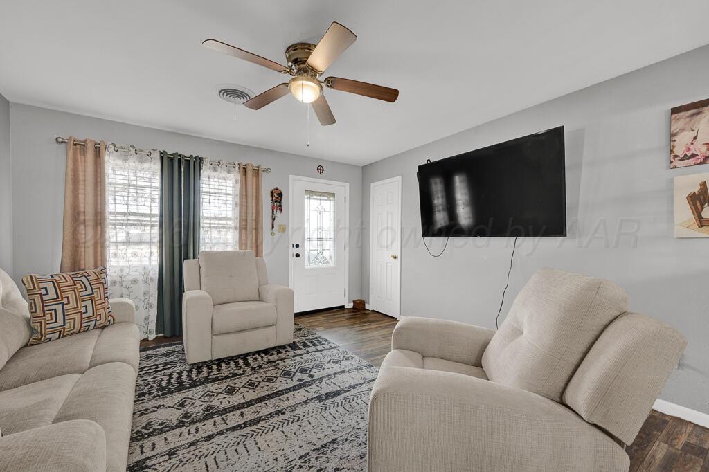 4613 South Bryan Street Amarillo, TX 79110 - Photo 5 of 16 a living room with furniture a flat screen tv and a window