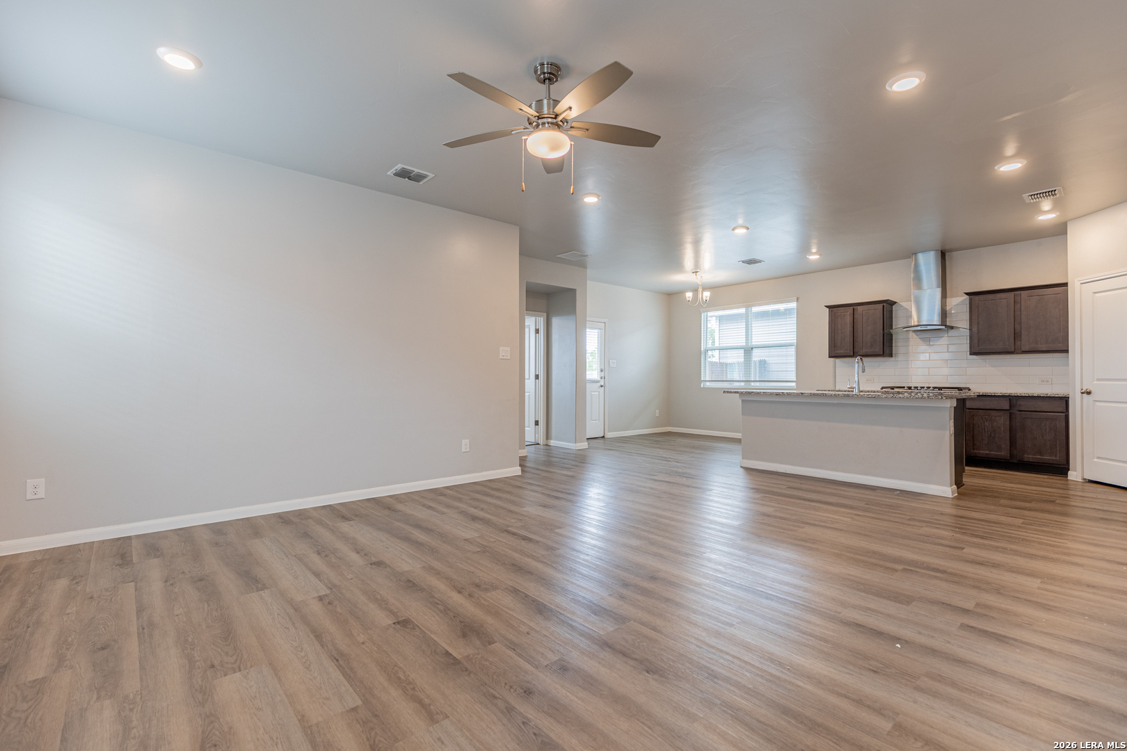 3923 Ivy Path St. Hedwig, TX 78152 - Photo 5 of 32 an empty room with wooden floor and a ceiling fan