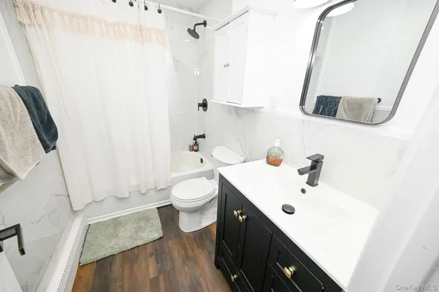 a bathroom with a sink a toilet and shower curtain