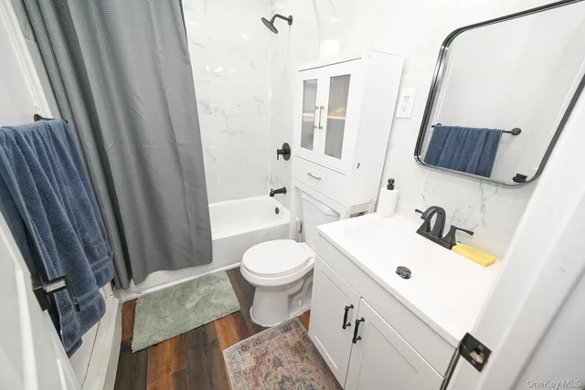 a bathroom with a sink a toilet and shower curtain