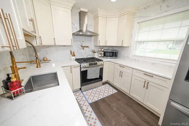 a kitchen with a stove white cabinetry and a sink