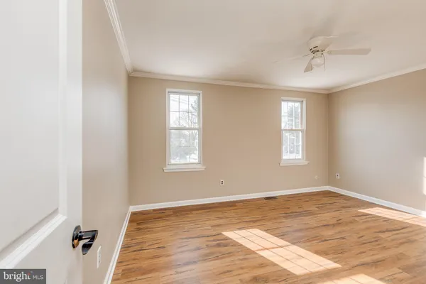 a view of a room with wooden floor and windows