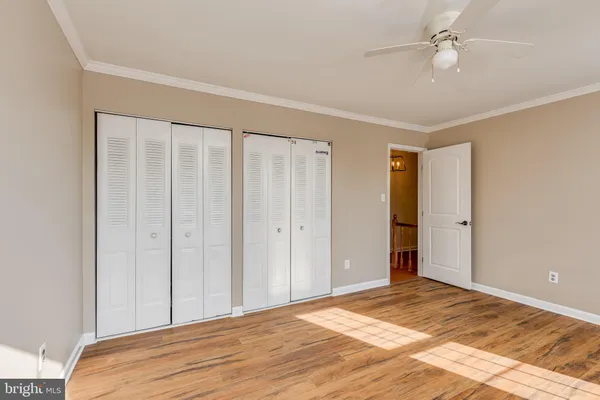 a view of a livingroom with wooden floor and a ceiling fan