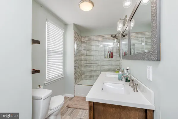 a bathroom with a sink a toilet and shower