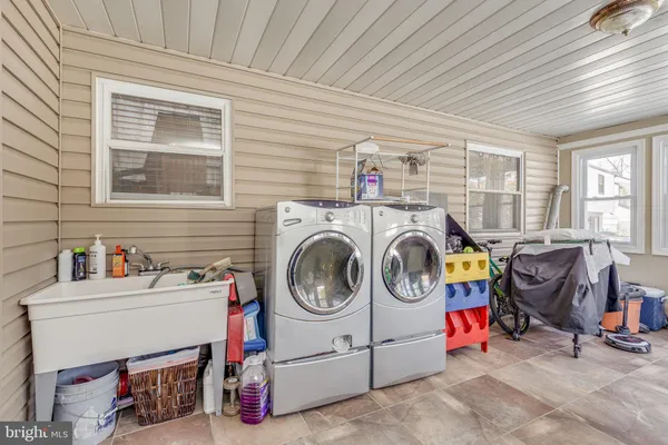 a utility room with dryer washer and a view of living room