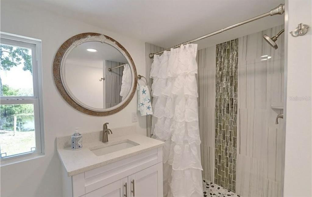 8164 East Turner Camp Road Inverness, FL 34453 - Photo 16 of 39 a bathroom with a sink a mirror a vanity and a shower