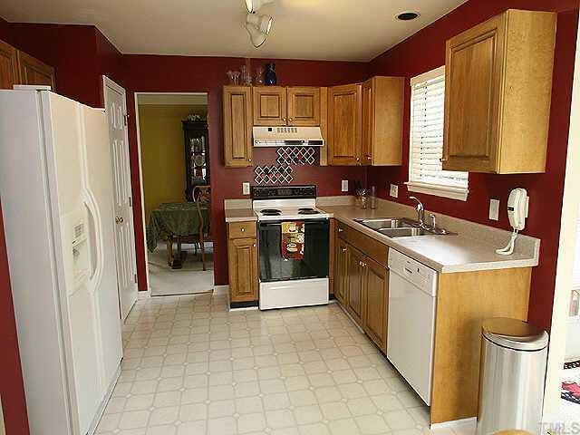 2504 Constitution Drive Raleigh, NC 27615 - Photo 4 of 9 a kitchen with stainless steel appliances granite countertop a refrigerator a sink dishwasher a stove with wooden cabinets