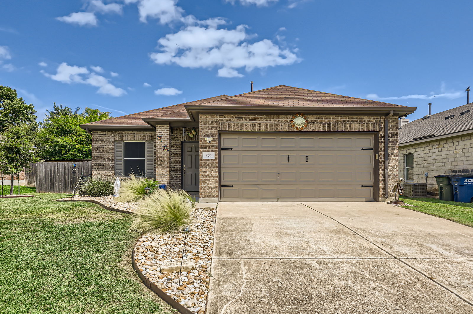 803 Ranchero Road Leander, TX 78641 - Photo 1 of 1 Front of the house with brick siding, an attached garage, concrete driveway, and a shingled roof