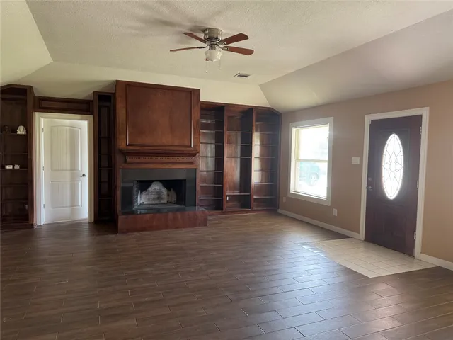 a view of a livingroom with wooden floor a fireplace and window