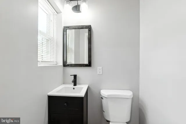 a bathroom with a toilet sink and mirror