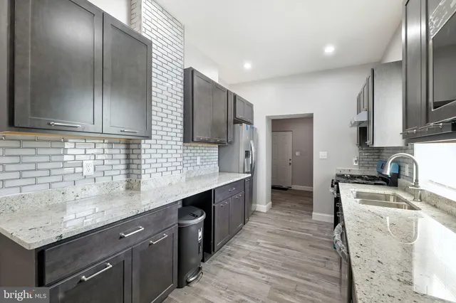 a kitchen with stainless steel appliances granite countertop a sink stove and refrigerator