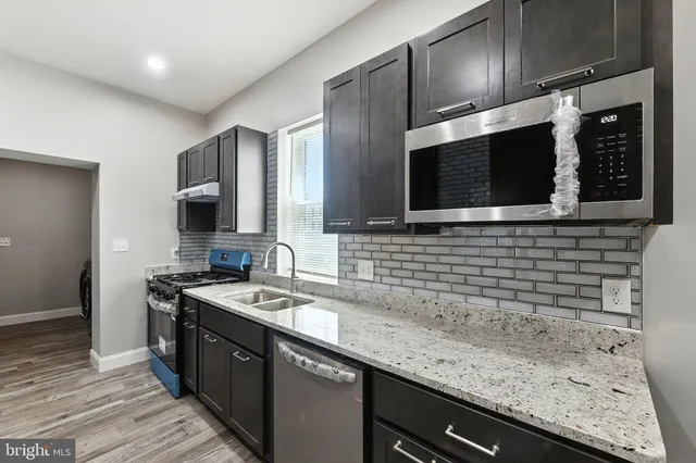 a kitchen with stainless steel appliances wooden cabinets a sink and a stove