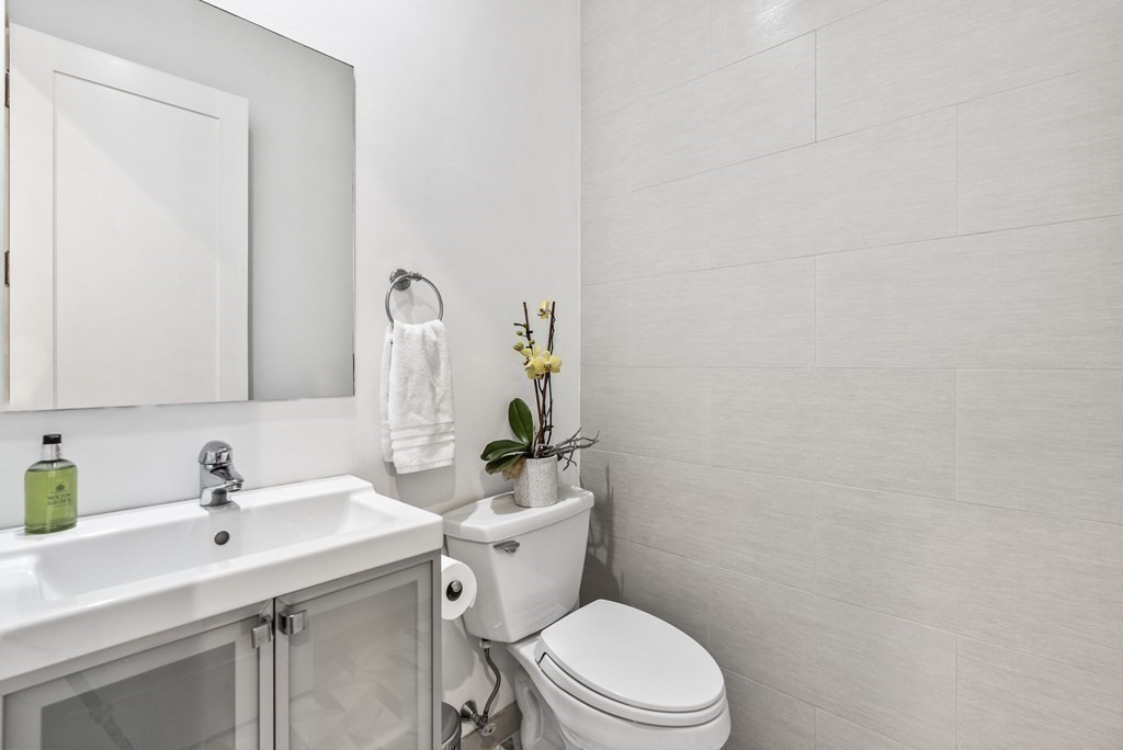 36 A, Unit 5E Boston, MA 02127 - Photo 23 of 38 a bathroom with a toilet sink and mirror