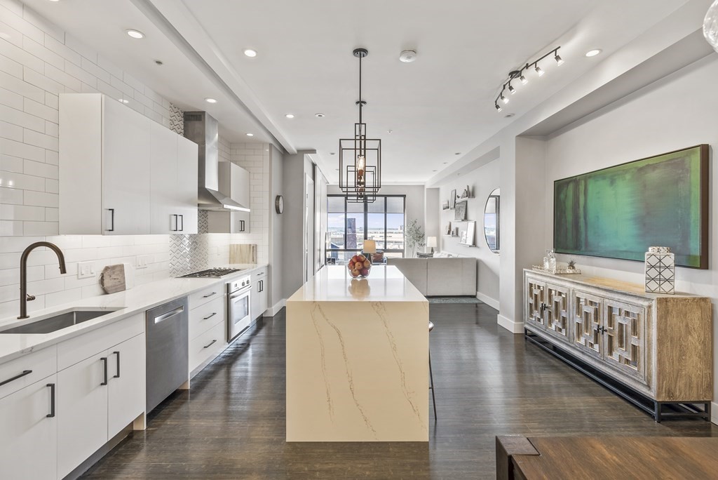 36 A, Unit 5E Boston, MA 02127 - Photo 8 of 38 a kitchen with stainless steel appliances granite countertop a white cabinets and wooden floor