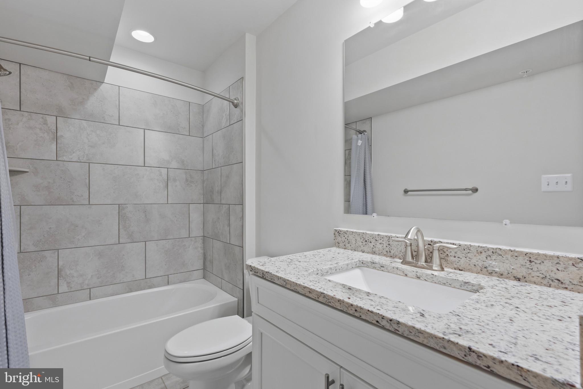 703 Perception Way Aberdeen, MD 21001 - Photo 28 of 42 a bathroom with a granite countertop sink a toilet and bathtub
