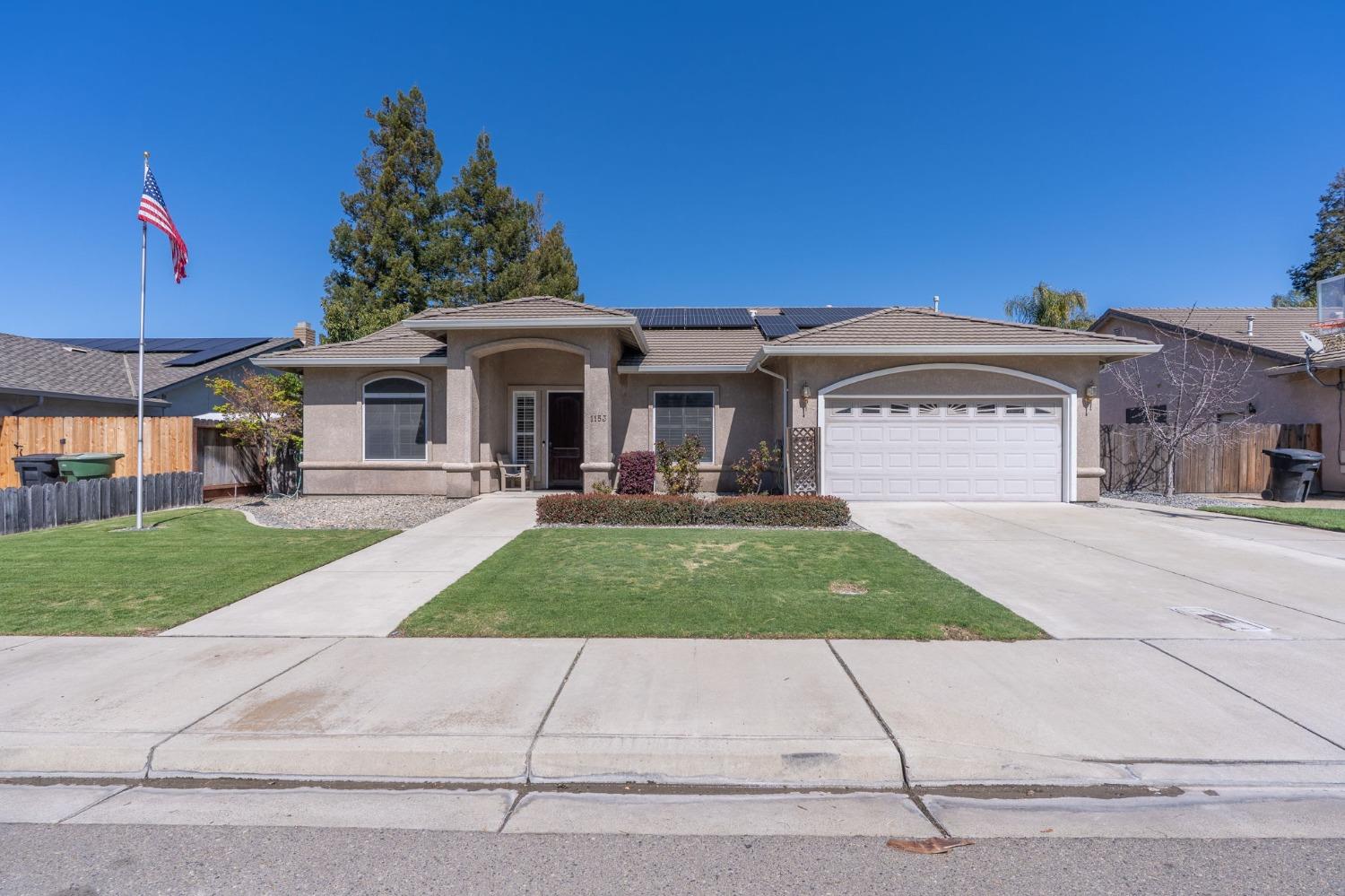 a front view of a house with a yard and a garage