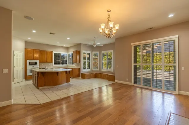 a large white kitchen with large windows and refrigerator