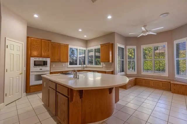 a kitchen with stainless steel appliances granite countertop a sink a oven and a refrigerator