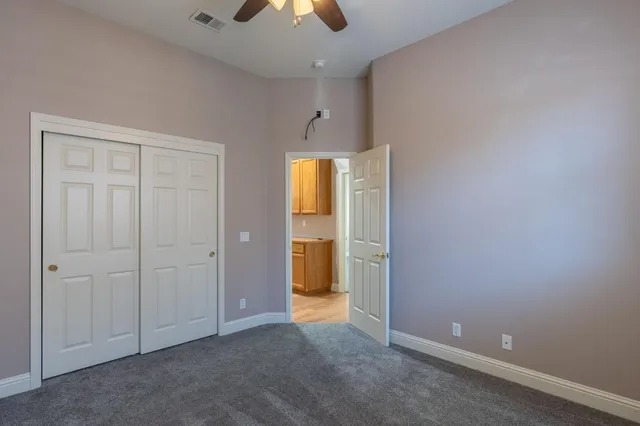 an empty room with closet and chandelier fan