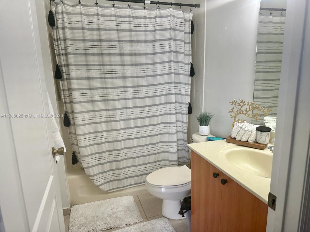 4830 Southwest 163rd Place Miami, FL 33185 - Photo 15 of 23 a bathroom with a sink a toilet and shower curtain