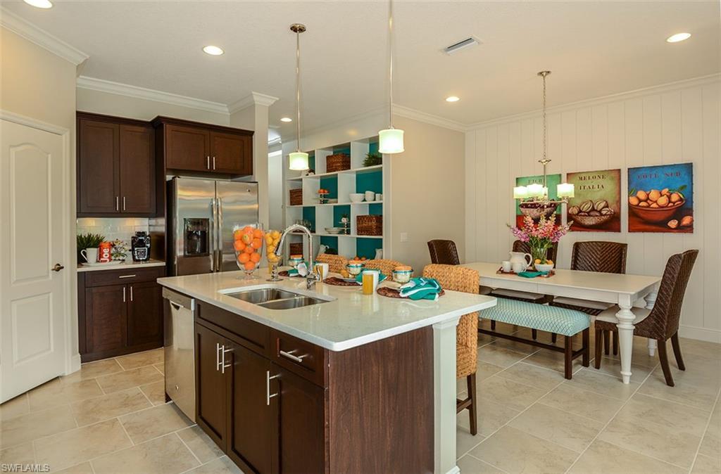 4665 Centaurus Circle Naples, FL 34120 - Photo 5 of 16 a kitchen with a sink stove and chairs