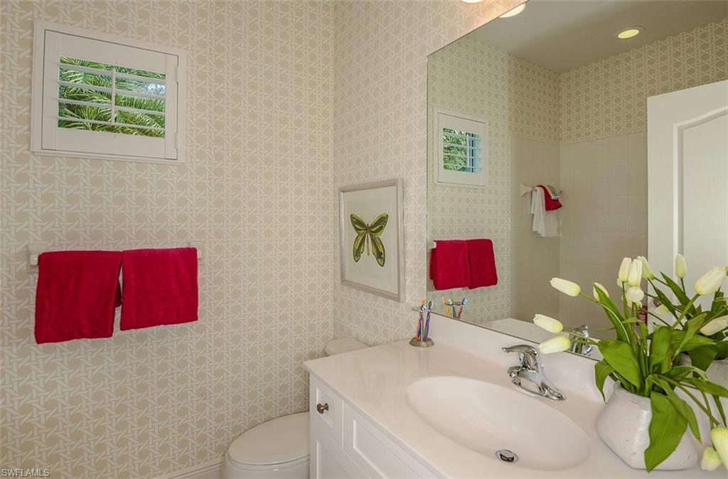 4665 Centaurus Circle Naples, FL 34120 - Photo 10 of 16 a bathroom with a toilet sink and mirror