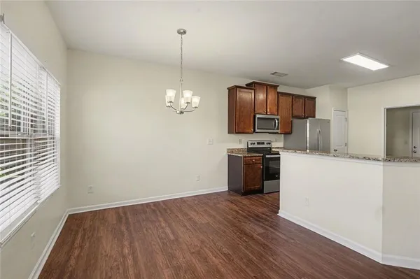 a kitchen with granite countertop a refrigerator and a stove top oven