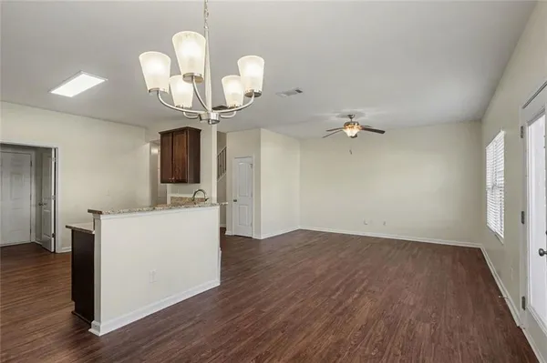 a view of a room with wooden floor and ceiling fan