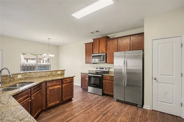 a kitchen with stainless steel appliances granite countertop a stove refrigerator and sink