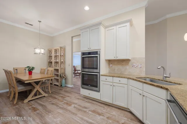 a kitchen with granite countertop white cabinets and stainless steel appliances