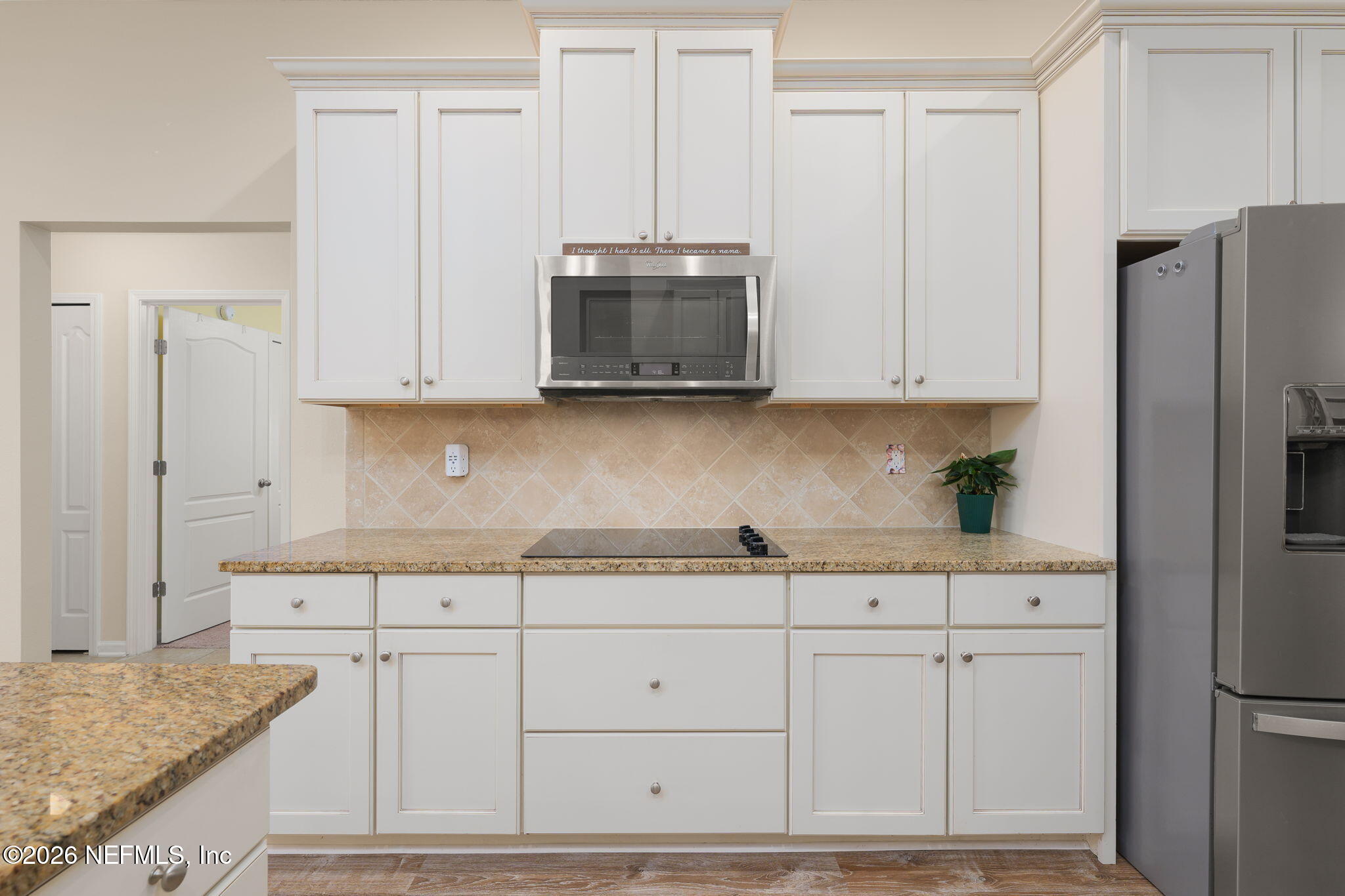 405 Porta Rosa Circle St. Augustine, FL 32092 - Photo 15 of 55 a kitchen with granite countertop white cabinets and stainless steel appliances