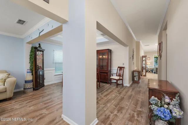 a living room with furniture a large window and wooden floor