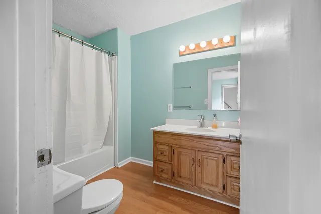a bathroom with a granite countertop sink a toilet and a mirror