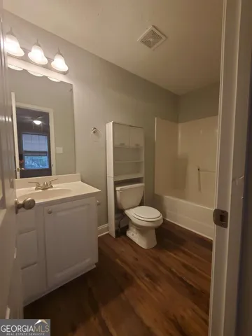 a bathroom with a sink mirror vanity and toilet