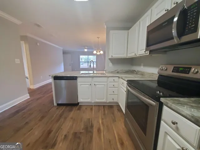 a kitchen with a sink a stove and cabinets