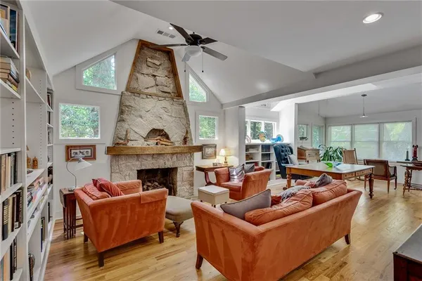 a living room with furniture fireplace and large windows