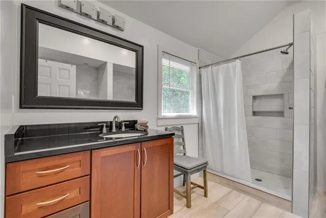 a bathroom with a sink a mirror and a shower